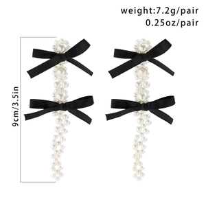 Detail of fabric tassel earrings with black bow, faux pearls and length measurement