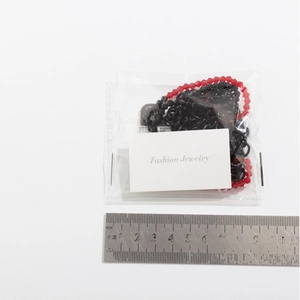 Detailed size measurement of magnetic heart necklace with measurement ruler on white card