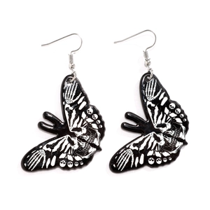 Macro detail of gothic butterfly skull earrings in black and white acrylic mirror finish