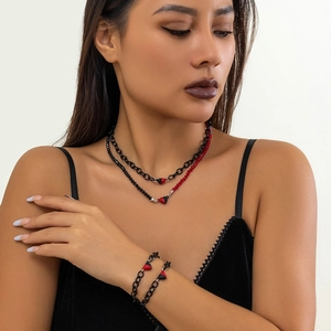 Detail of red and black heart pendants on layered beaded necklaces and matching bracelets