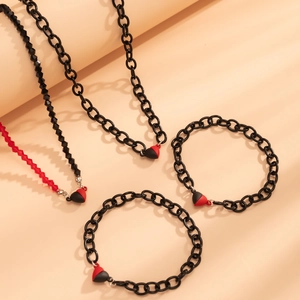 Detailed view of vintage magnetic heart necklaces and bracelets set with red beads