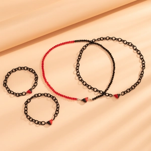 Detailed view of red and black magnetic heart necklaces with matching bracelet sets