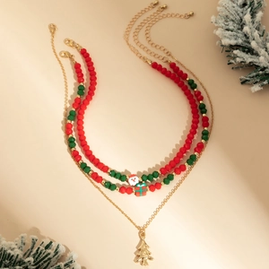 Detailed close-up of layered Christmas necklace with Santa, gift box and tree charms