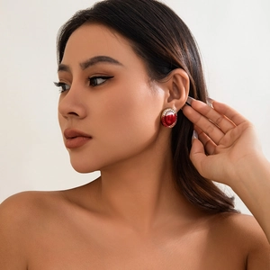 Close-up of vintage gothic red oval stud earring with white pearl border on model