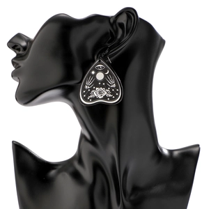 Gothic acrylic earring featuring all-seeing eye and skeleton hands on a black model