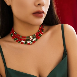 Close-up of multilayer Christmas beaded necklace with festive charms on a model