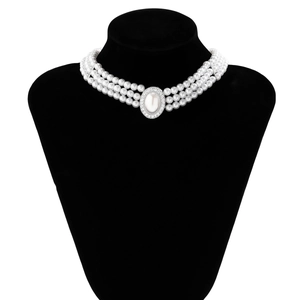 Détail d'un ras de cou à trois rangs de perles avec médaillon central orné de cristaux