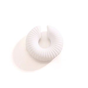 Dettaglio macro dell'ear cuff bianco a coste con trama a strisce verticali