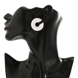 Dettaglio macro di earcuff in resina bianca con strisce radiali su manichino nero