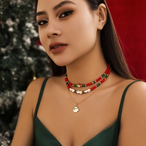 Three-layer Christmas choker necklace featuring green beads and a snowman charm detail