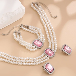 Détail d'un ensemble de bijoux en perles à trois rangs avec pierres roses et fermoir