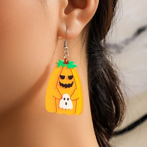 Close-up of glittery acrylic Halloween earrings featuring a cute pumpkin and ghost design