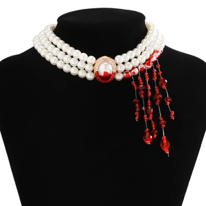 Macro detail of gothic choker with three-layer pearls, blood-drop tassels and red gemstone