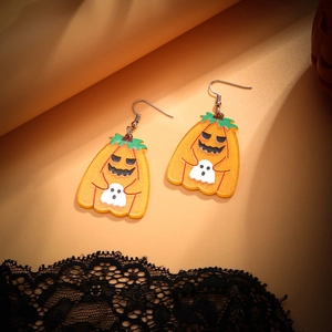 Macro view of Halloween acrylic pumpkin earrings with glitter and ghost detail