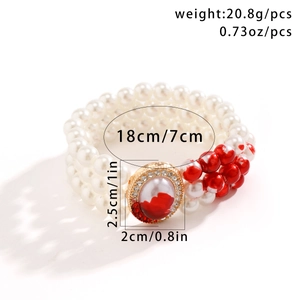 Detailed view of triple-layer pearl bracelet with red drip beads and jeweled oval pendant