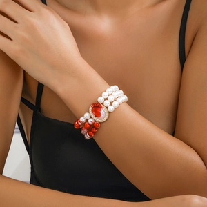 Close-up of triple-layer pearl choker with red oval gemstone and dripping blood tassels