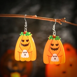 Detail of glittery acrylic Halloween earrings featuring pumpkin and ghost hanging on a branch