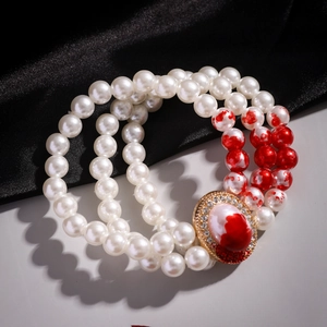 Macro shot of Gothic pearl choker with red blood drip effects and rhinestone oval pendant