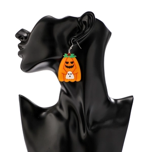 Detail of Halloween pumpkin and ghost earrings on a black display mannequin model