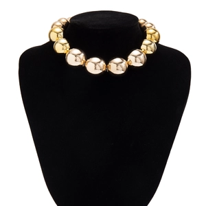 Détail du collier choker à billes dorées polies sur un présentoir noir élégant
