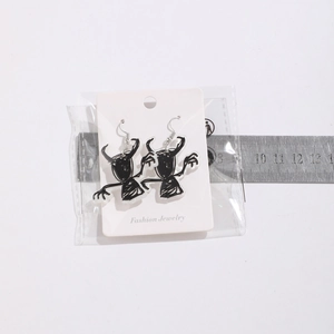 Detail view of black acrylic monster earrings with steel ruler for size measurement