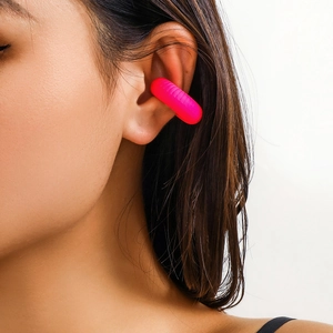 Dettaglio di un ear cuff rosa con trama a spirale rigata indossato sul padiglione