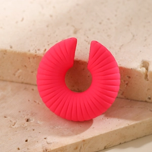 Dettaglio dell'orecchino a clip a C rosa neon con trama a coste su base di pietra