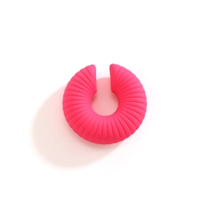 Dettaglio dell'orecchino a clip rosa acceso a forma di C con superficie plissettata