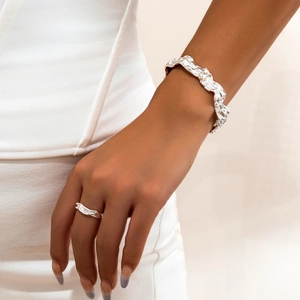 Detail van vloeibare lavatectuur op zilveren armband en bijpassende ring op model