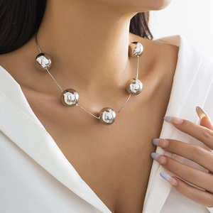 Détail des boules en métal argenté poli sur un collier ras du cou de style punk
