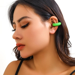 Dettaglio di un ear cuff verde acceso testurizzato sulla cartilagine senza buco