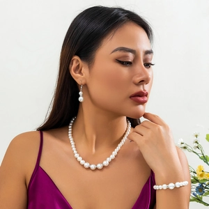 Detailopname van barokke parelsieraden set met ketting, armband en oorbellen op het model