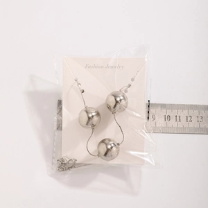 Détail d'un tour de cou punk argenté avec grandes billes miroir et règle pour taille