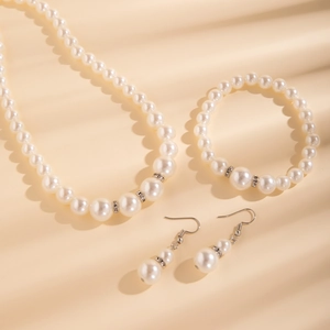 Detail van een meerlaagse parelset met ketting, armband en oorbellen met zilveren details