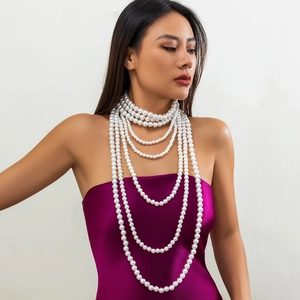 Detail van elegante meerlaagse parelketting op een paarse satijnen jurk