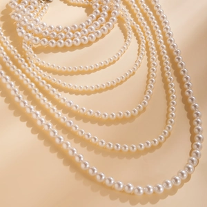 Detail van gelaagde barokke parelketting met elegante crèmewitte kralen en metalen sluiting