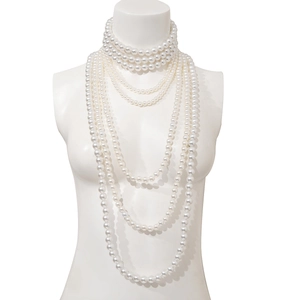 Detail van een meerlaagse barokke parelketting met elegante crèmeglans op een etalagepop