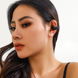 Dettaglio di un ear cuff a spirale nero opaco indossato sull'orecchio senza buco