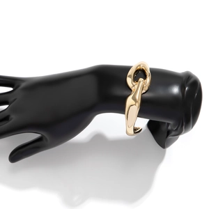 Dettaglio di un bracciale a catena d'oro lucido su un modello da esposizione nero opaco