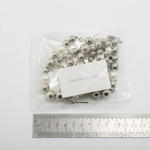 Vue détaillée du collier punk avec perles en métal argenté et perles dans l'emballage