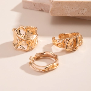 Driedelige gouden ringenset met onregelmatige lavastructuur en golvende ontwerpdetails