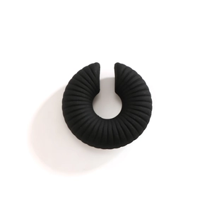 Dettaglio di un ear cuff nero opaco a forma di C con decorazione a righe verticali