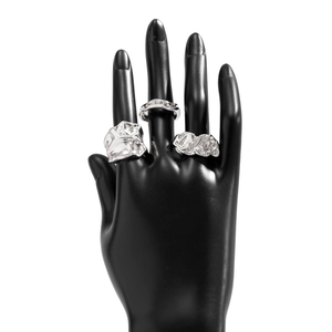 Detail van zilveren lava ringen met onregelmatige textuur en vouwen op een handmodel