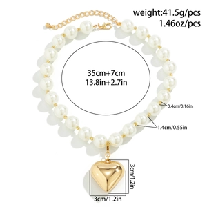 Macro detail of chunky white pearl necklace with gold heart pendant and size dimensions