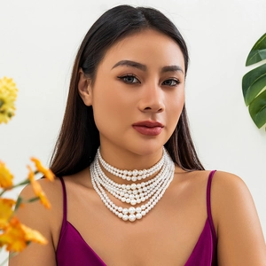 Detailopname van meerlaagse barokke parelketting met elegante drapering op model