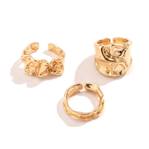 Detail van drie onregelmatige gouden ringen met lavatextuur en verstelbaar open design