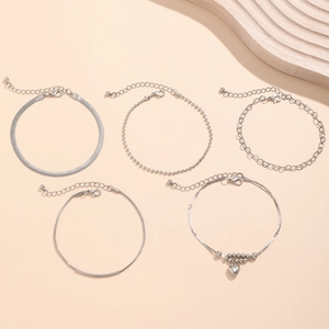 Detail of 5-piece silver anklet set featuring heart charms, snake and beaded chains