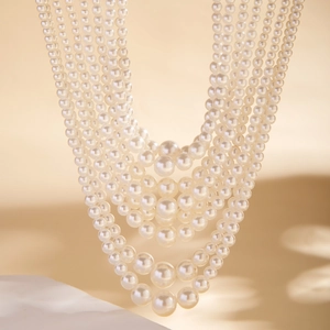 Macrodetail van een gelaagde parelketting met elegante barokke kralen in gradiënt