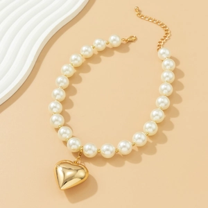 Detail of elegant pearl choker featuring a polished gold 3D heart-shaped pendant
