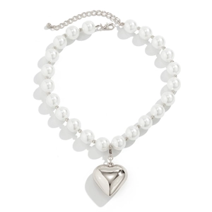 Detail of white pearl necklace with large silver heart pendant and lobster clasp